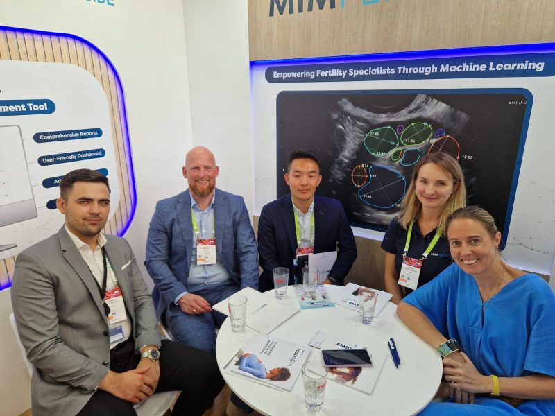 A picture of people sitting at a table at the MIM fertility booth